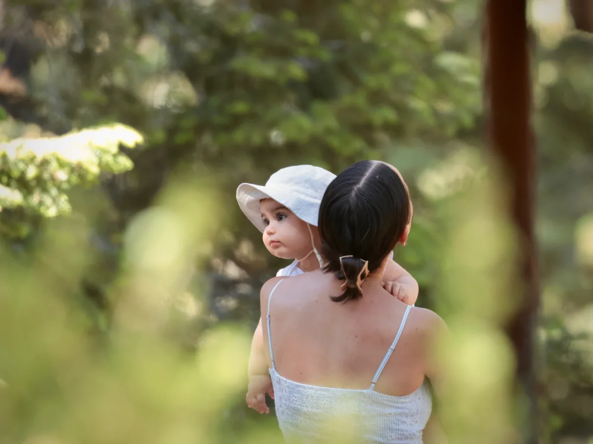 My wife carrying our son through the forest